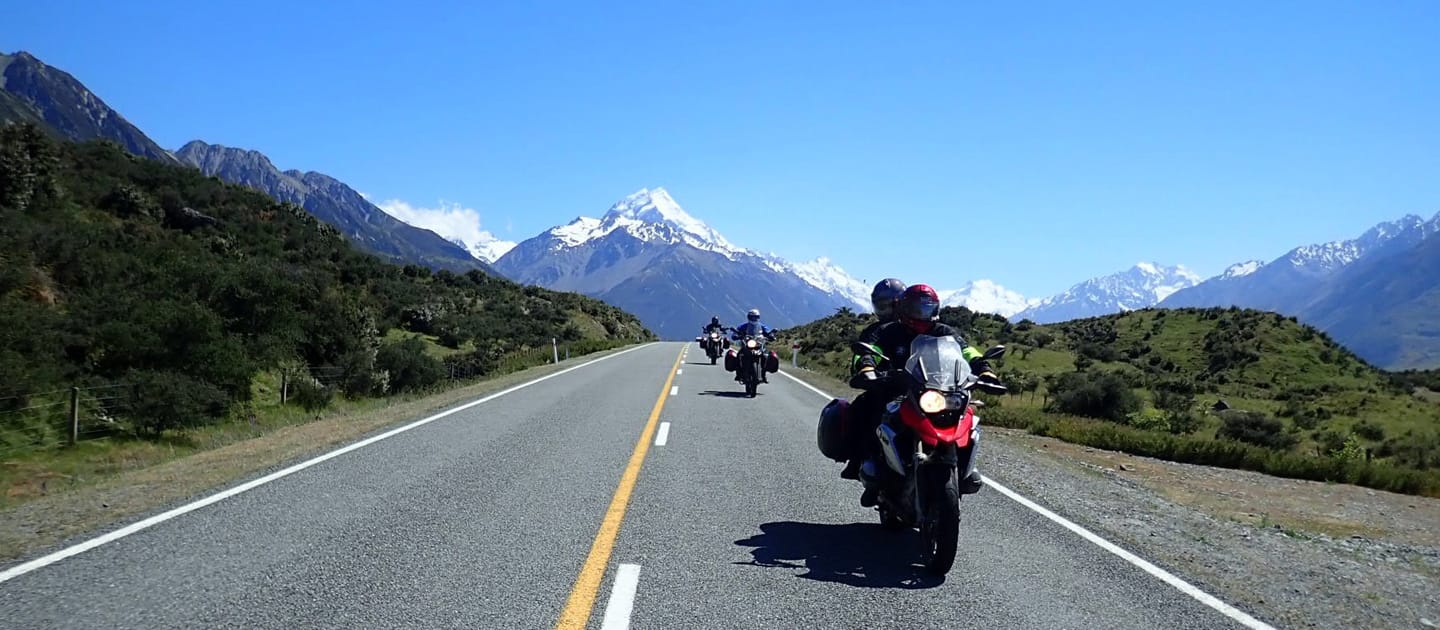 Moottoripyöräilijöit Uudessa-Seelannissa vuoria taustallaan