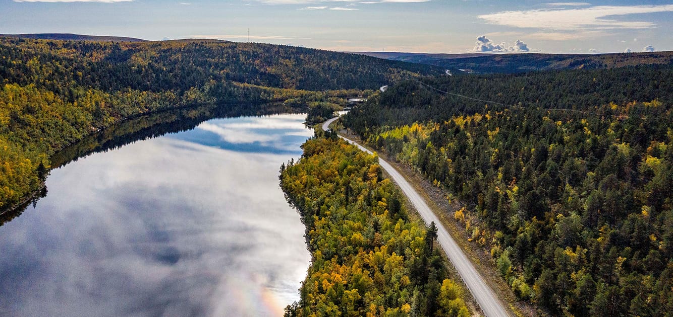 Suomalainen maisema, joki ja sen vieressä kulkee tie