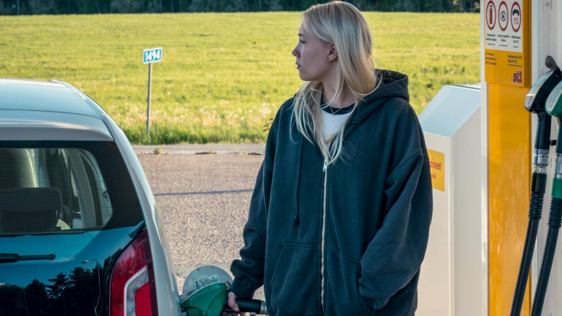 nuori nainen tankkaa autoaan